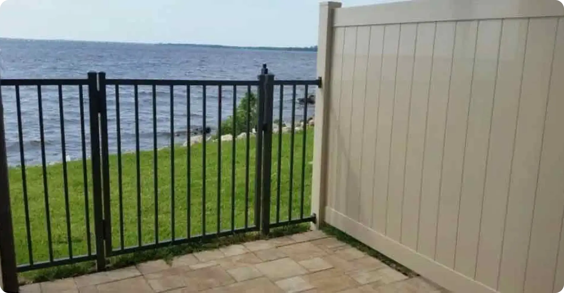 Black aluminum fence and tan vinyl privacy panel on a waterfront patio by Premier Fence of SWFL