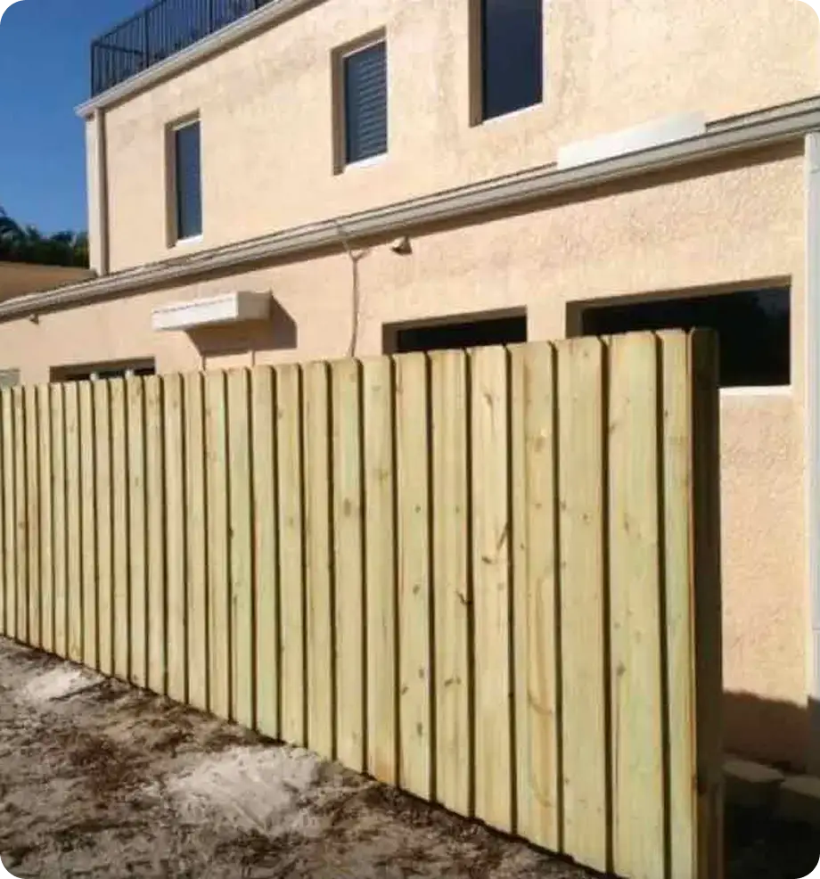 Vertical wood privacy fence along the side of a home by Premier Fence of SWFL
